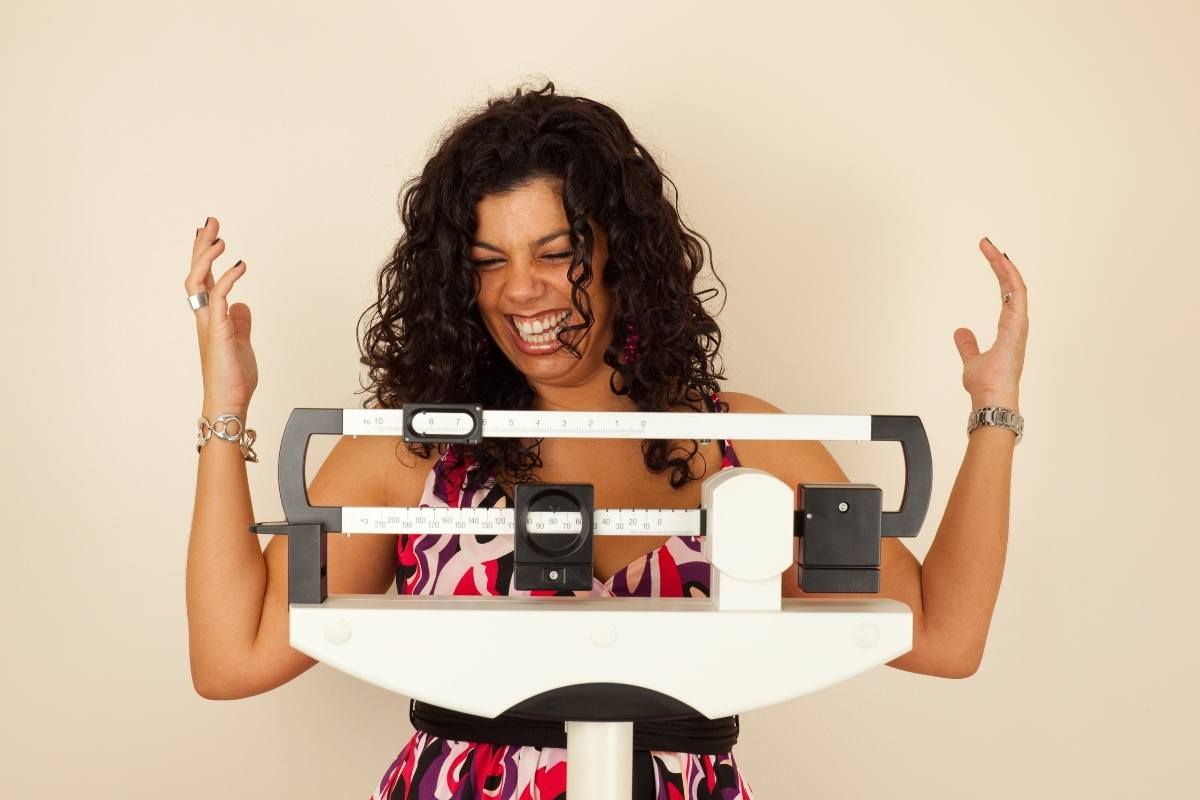 happy woman standing on scale