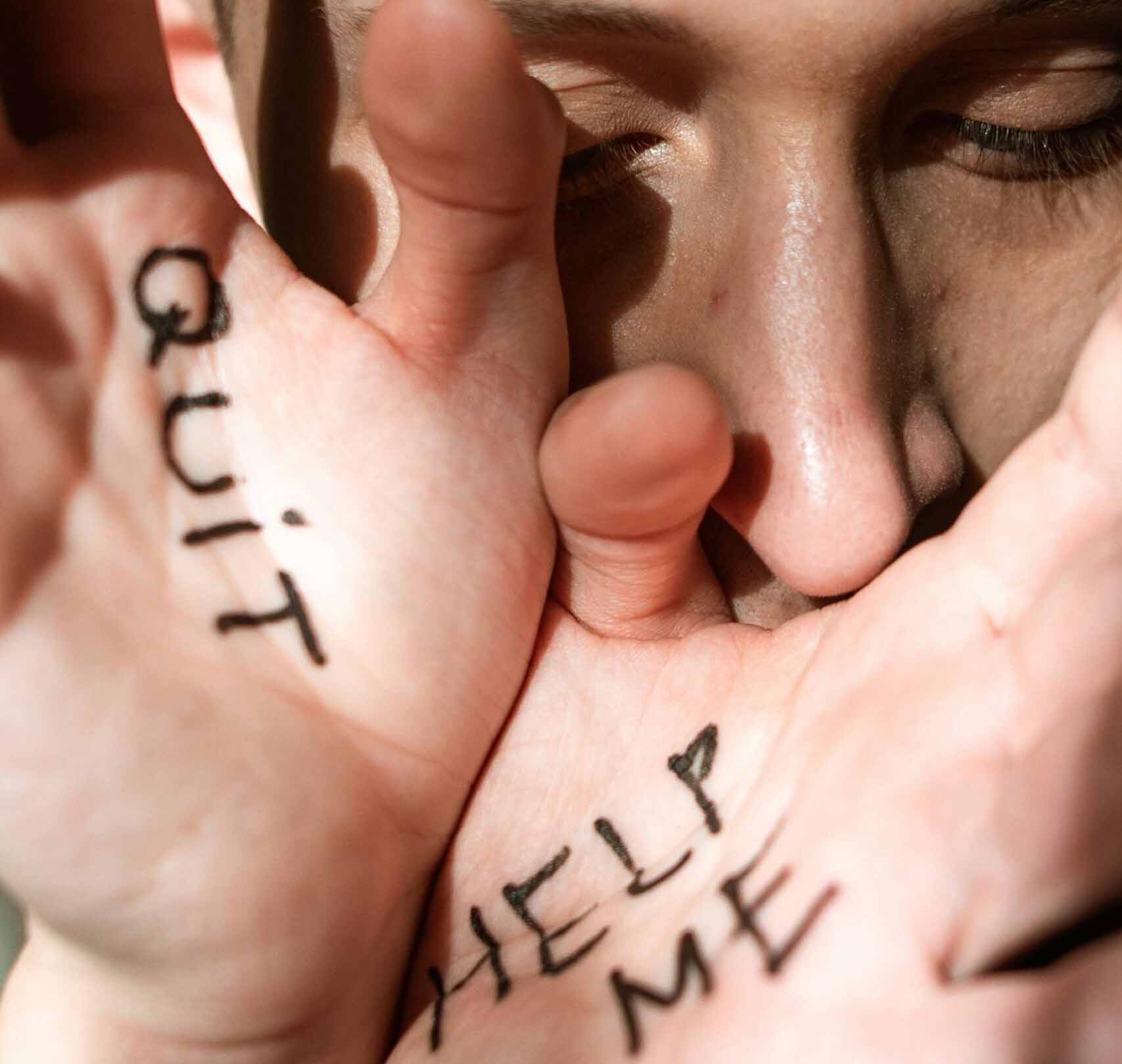 Girl with 'Quit' and 'Help Me' text on her hand