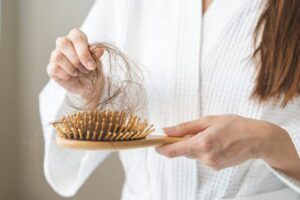 woman pulling hair from hair brush